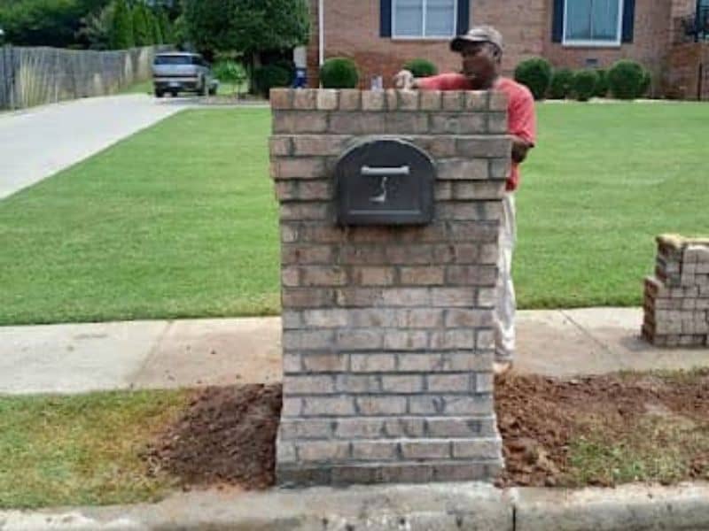 building a brick mailbox post in front of a residential home