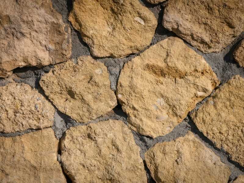 Natural stone patio with irregular stone pavers and visible joints that require proper maintenance for long-term durability.