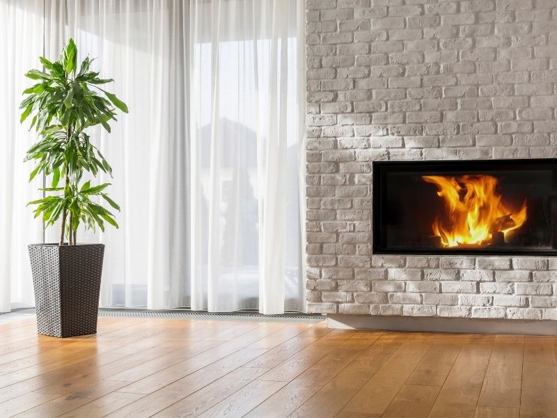 Brick Fireplace Offset Chimney Huntsville AL - Huntsville Brick Stone Off-center brick fireplace beside a large window with a balanced room layout in Huntsville, Alabama.