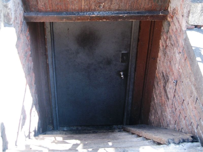 Below grade storm shelter entryway with brick masonry walls and a secure entrance door in Huntsville AL.